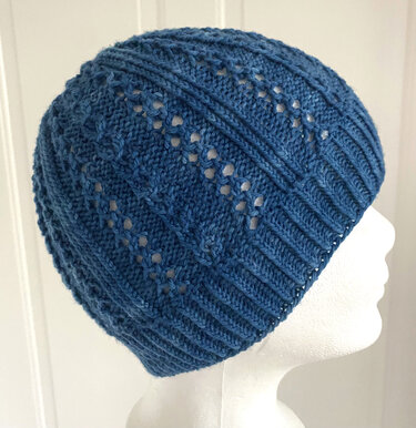 Blaue Strickmütze mit Ajour- und Rippenstruktur auf weißem Modellkopf