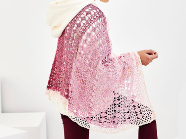 Gehäkeltes Rechtecktuch mit Rosa‑Creme‑Farbverlauf über hellem Hoodie