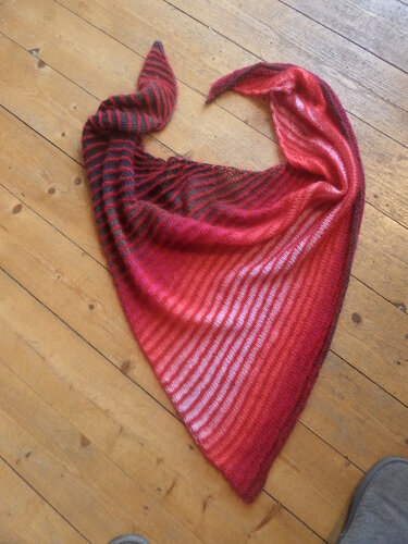 Gestricktes Dreieckstuch mit Rot-, Pink- und dunklen Streifen auf Holzboden