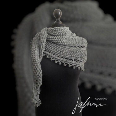 Grey crochet triangle shawl with bobble rows on black mannequin