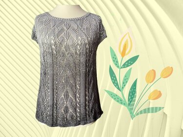 Gestricktes graues Damen-Top mit Blatt-Ajourmuster, kurzen Ärmeln und Rundhalsausschnitt vor hellem Hintergrund