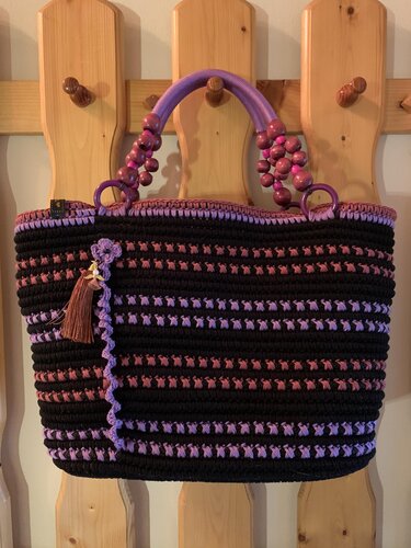 Schwarz-lila-rosafarbener gehäkelter Shopper mit Holzperlengriffen und Quaste, ideal für den Einkauf.