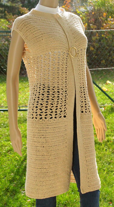 Beige gehäkelte lange ärmellose Weste mit Lochmuster und rundem Ringverschluss auf Mannequin