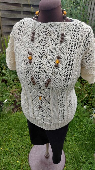 Beiges gestricktes Damen-Oberteil mit Ajour- und Lochmuster auf Schneiderpuppe
