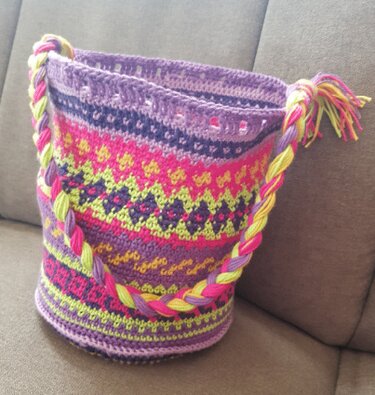 Gehäkelte Zylindertasche mit mehrfarbigen Streifen, Ösenreihe und geflochtenem Tragegurt