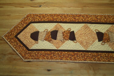 Patchwork-Tischläufer in Herbstfarben mit applizierten Körbchen und gesteppten Mustern