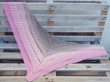 Gehäkeltes Dreieckstuch mit Farbverlauf in Rosa und Braun auf Holzpaletten