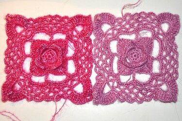 Zwei gehäkelte Granny-Squares mit Rosenapplikation in Rot- und Rosatönen auf hellem Hintergrund
