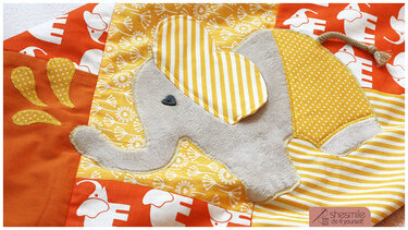 Nahaufnahme einer Patchworkanordnung mit appliziertem Elefanten und gestreiften sowie gepunkteten Stoffen