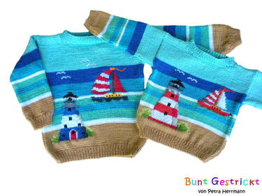 Zwei gestrickte Kinderpullover mit nautischen Motiven: Leuchttürme und Segelboote in Blau-, Rot- und Brauntönen mit gestreiften Ärmeln.