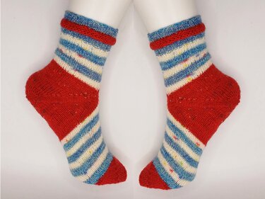 Gestrickte Socken mit roten Fersen und Spitzen, blauem Bündchen und rot-weiß-blauen Streifen