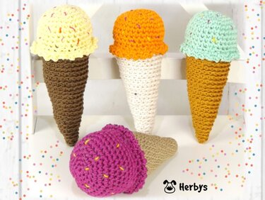 Vier gehäkelte Eiswaffeln in Gelb, Orange, Mintgrün und Fuchsia mit Streuseln auf weißem Hintergrund