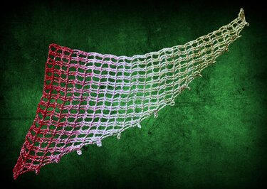 Gehäkeltes offenes Dreieckstuch mit Netzgitter und Farbverlauf von Rot über Rosa zu Beige vor grünem Hintergrund