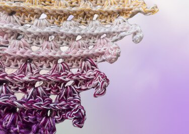 Detailaufnahme gehäkeltes Dreieckstuch, Farbverlauf Gelb
RosaViolett mit Muschel- bzw. Fächerstichen und schimmerndem Garn.