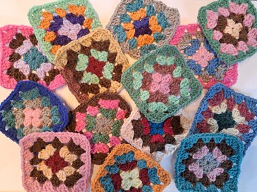 Assorted crochet granny squares in mixed colors laid out flat