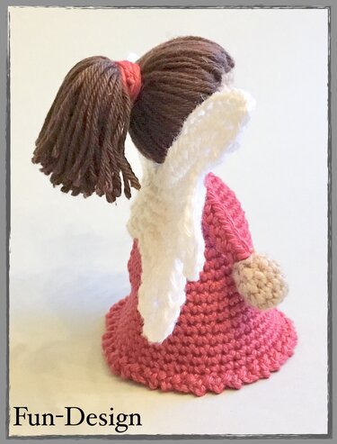 Gehäkelte Engelsfigur in rosa Kleid mit braunem Zopf und weißen Flügeln, Rückansicht