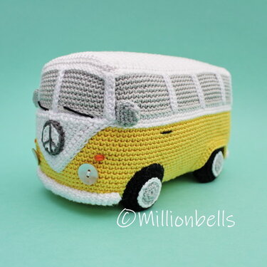Yellow and white crocheted camper van amigurumi with button headlights and peace symbol