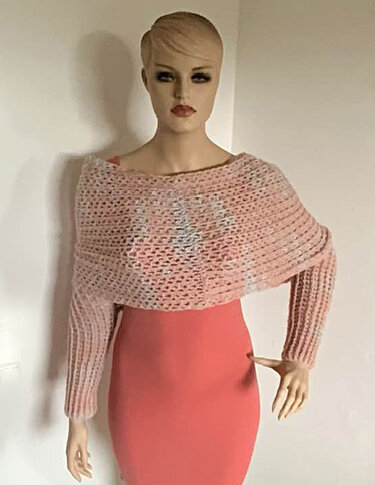 Mannequin mit rosa gehäkeltem Schultertuch mit langen Ärmeln über einem enganliegenden Kleid