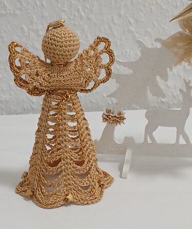 Amigurumi-Häkelengel mit offenem Spitzenrock, goldenen Flügelsäumen und kleinen Glöckchen
