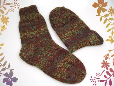 Paar gestrickter Socken aus braun-grün meliertem Garn mit Rippenbund auf weißem Hintergrund