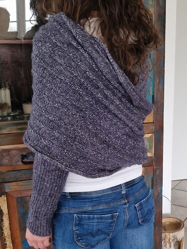 Rückansicht einer Person mit meliertem dunkelviolettem Bolero-Schal und Jeans