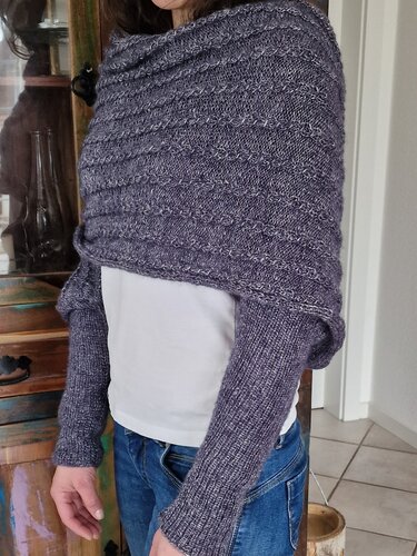 Gestrickter Shrug in Grau-Lila Melange mit Strukturmuster und langen Ärmeln, getragen