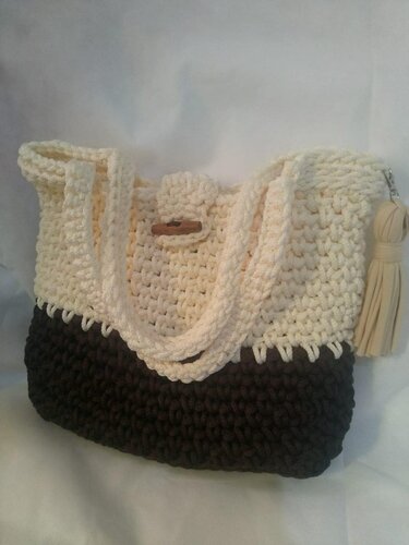 Two-tone crocheted shoulder bag in cream and dark brown with wooden toggle and tassel.