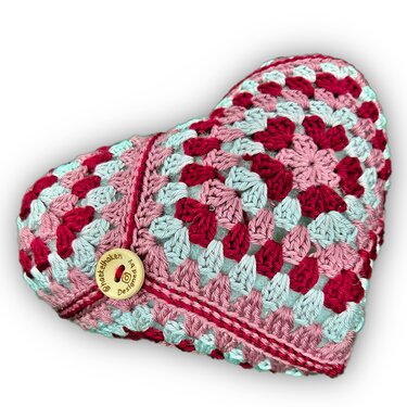 Gehäkeltes Herzkissen aus Granny-Squares in Rosa, Rot und Hellblau mit Holzknopf