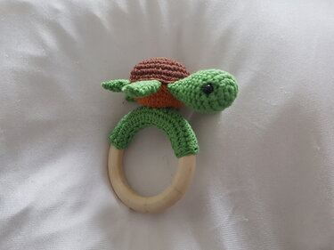 Gehäkelter Schildkröten-Beißring mit naturfarbenem Holzring und grüner Umhäkelung