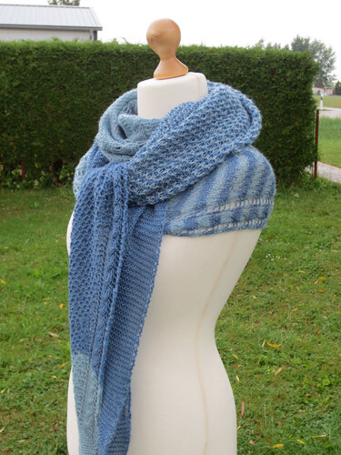 Gestricktes Halbrundtuch in Blautönen mit Lochmuster auf einer Schneiderpuppe im Freien