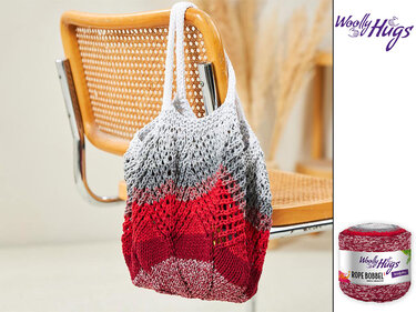 Gestrickte Netztasche in Rot- und Grautönen mit Lochmuster an einer Stuhllehne; Garnknäuel rechts sichtbar