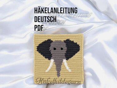 Quadratisches gehäkeltes Pixelmotiv mit Elefantenkopf in Grau und Schwarz auf beigem Hintergrund.