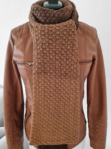 Brauner gehäkelter Schal mit strukturiertem Maschenbild über brauner Jacke an Schaufensterpuppe