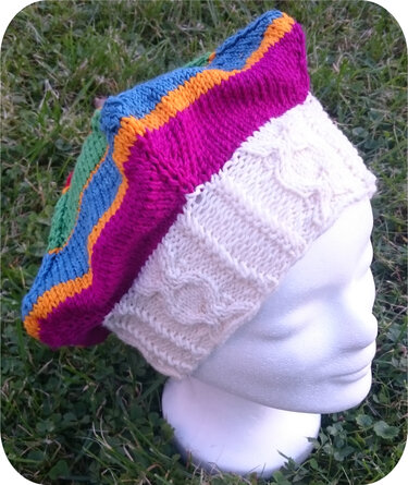 Colorful hand-knitted slouchy beret with cream cable rib band on a white mannequin head