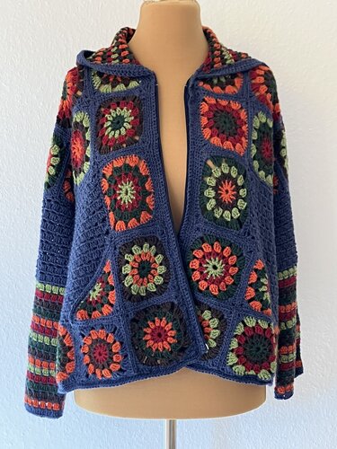 Damen-Häkeljacke aus bunten Granny-Squares mit Kapuze auf Schneiderpuppe