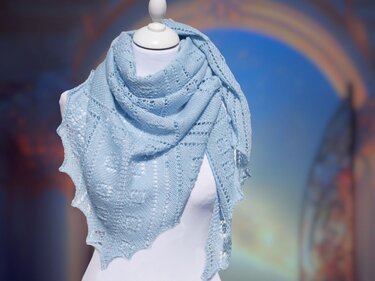 Hellblaues gestricktes Dreieckstuch mit Ajourmuster und gezacktem Rand auf weißer Schaufensterpuppe