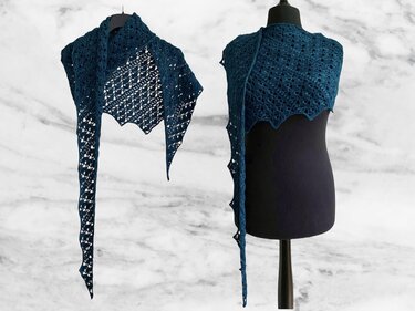 Deep teal crocheted dragon-tail scarf with lace pattern and scalloped edge displayed on a black dress form and hanging