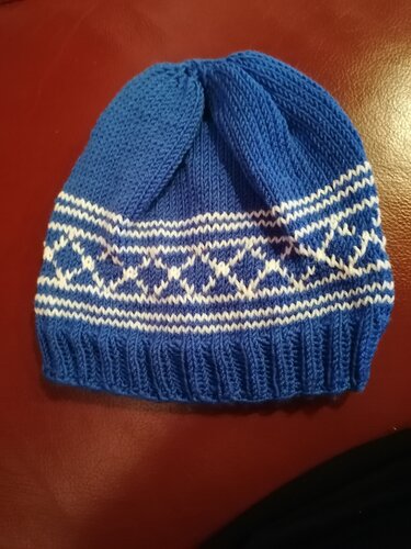Blaue gestrickte Kindermütze mit weißem Norwegermuster und Rippbündchen