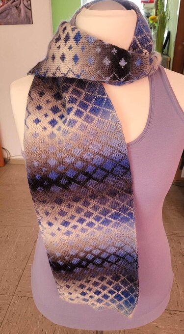 Gestrickter Schal mit Rautenmuster und Farbverlauf in Blau-, Grau- und Beigetönen auf einer Schaufensterpuppe