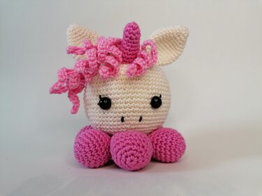 Gehäkeltes Einhorn-Amigurumi mit Horn, rosa Lockenmähne und schwarzen Sicherheitsaugen