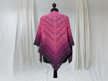 Gehäkeltes Dreieckstuch in verlaufendem Pink und Violett auf einer schwarzen Schneiderpuppe