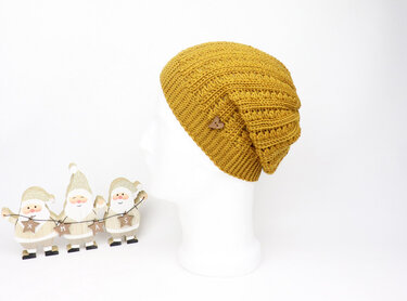 Mustard crochet slouchy beanie on white mannequin with wooden button