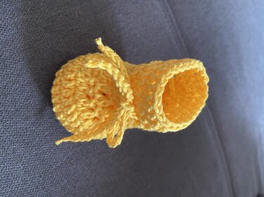 Gehäkelter gelber Babyschuh mit Bindeschnur