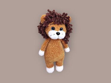 Gehäkelter Amigurumi-Löwe mit braunem Körper, dunkler Lockenmähne und weißer Schnauze.