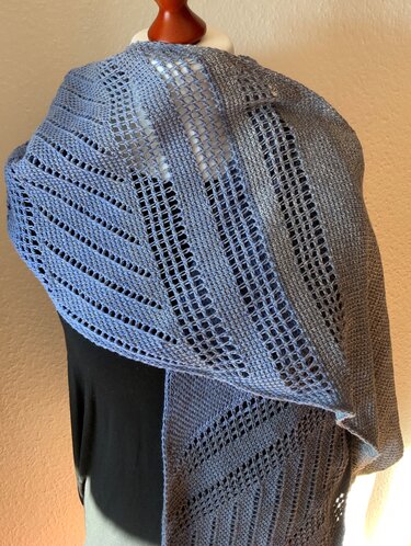 Tunesisch gehäkeltes Dreieckstuch in Hellgrau-Blau mit Loch- und festen Streifen auf Schneiderpuppe