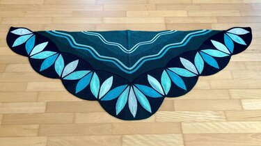 Gestricktes Dreieckstuch dunkelblau mit türkis-blauen Blattmotiven und gewelltem Rand