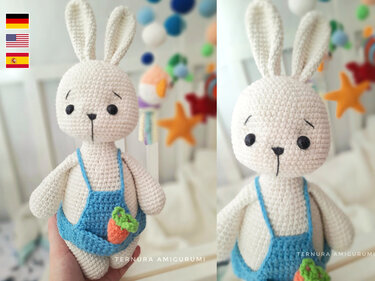 Cream crocheted amigurumi rabbit wearing blue overalls with carrot detail