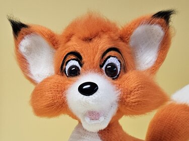 Frontalansicht eines niedlichen roten Amigurumi-Fuchses mit weißer Schnauze