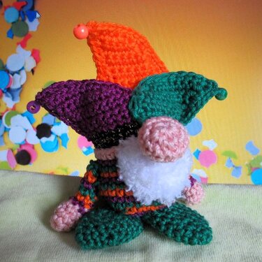 Gehäkelter Wichtel mit dreispitziger Narrenmütze in Orange, Lila und Grün und weißem Bart