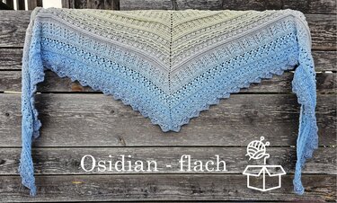 Gehäkeltes Dreieckstuch in Grau und Blau mit Spitzenkante auf einer Holzbank drapiert